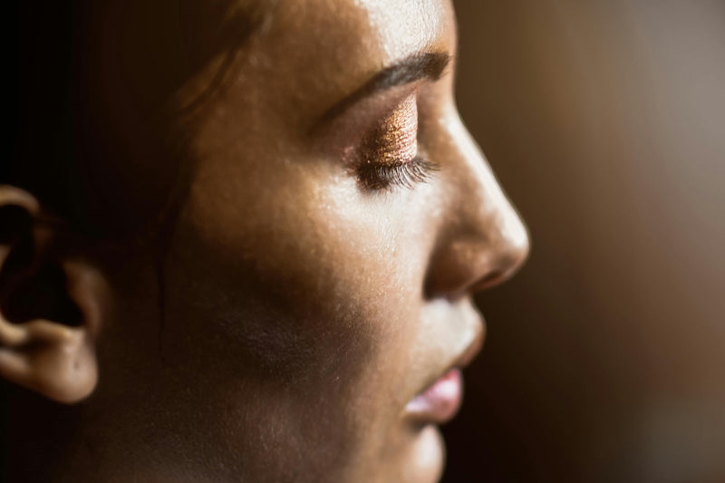 Profile of a woman with glowing skin and eyes closed
